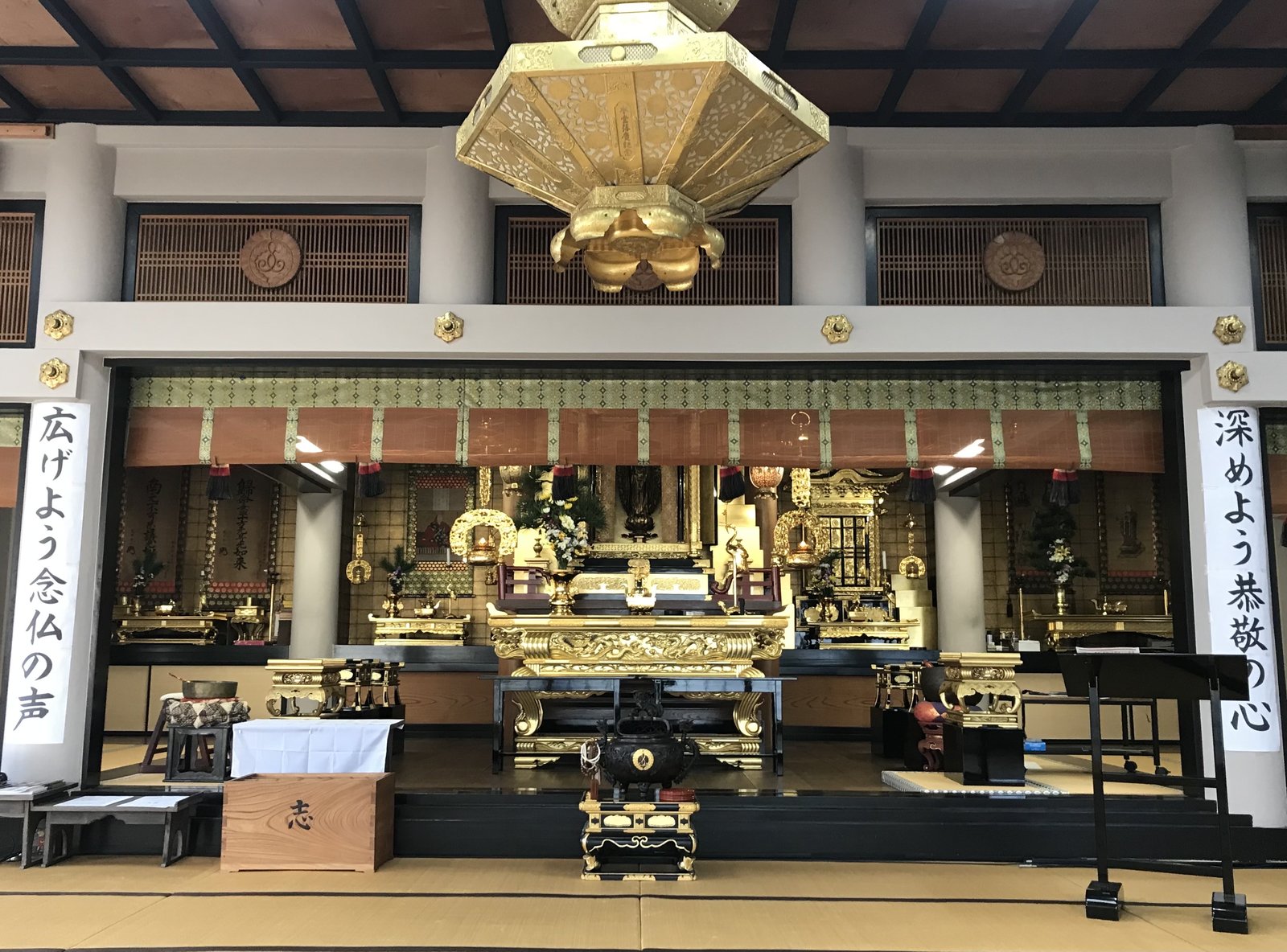 西光寺の本堂内部。金色の吊り灯籠と御本尊
